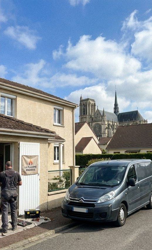 Technicien devant un garage avec la bâche La Flamme Briarde, cathédrale de Meaux derrière